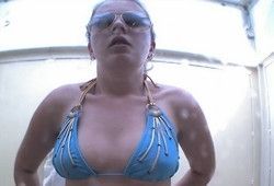 Через зеркало подглядывают за девушкой в душевой кабинке на пляже